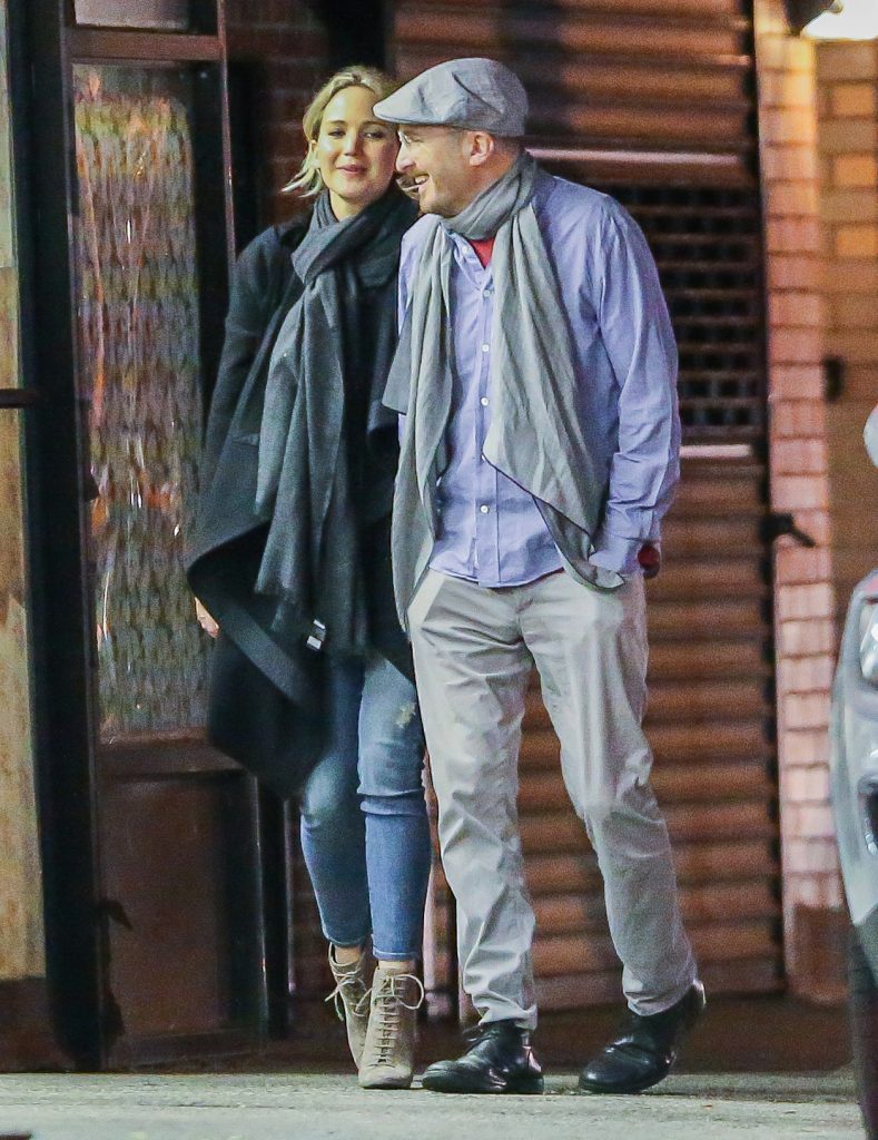 PREMIUM EXCLUSIVE: Jennifer Lawrence and Darren Aronofsky take an evening stroll together in New York City. The high heeled 26 year old actress and the flat capped film director 47 laughed, linked arms and stopped to kiss outside a flower stall as they strolled the city together after a romantic dinner. The photos of the couple appear to confirm recent rumors claiming that the pair have been dating. Please byline:TheImageDirect.com